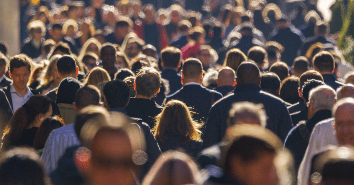 a crowd of people walking in a public area