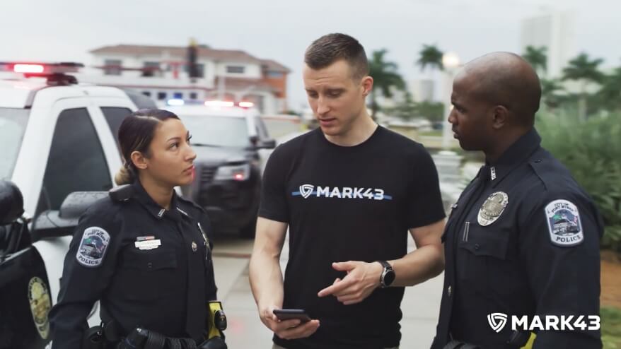 Mark43 team member speaking with two police officers next to police cars