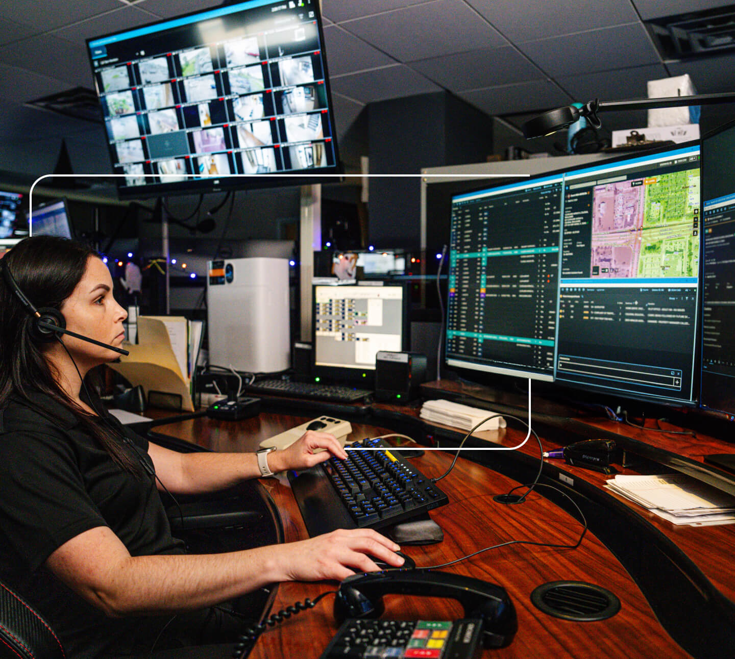 a female dispatcher wearing a headset and working on her computer screens