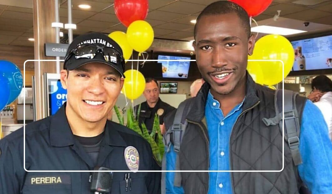 Officer Pereira smiling with citizen inside an event at a McDonald's