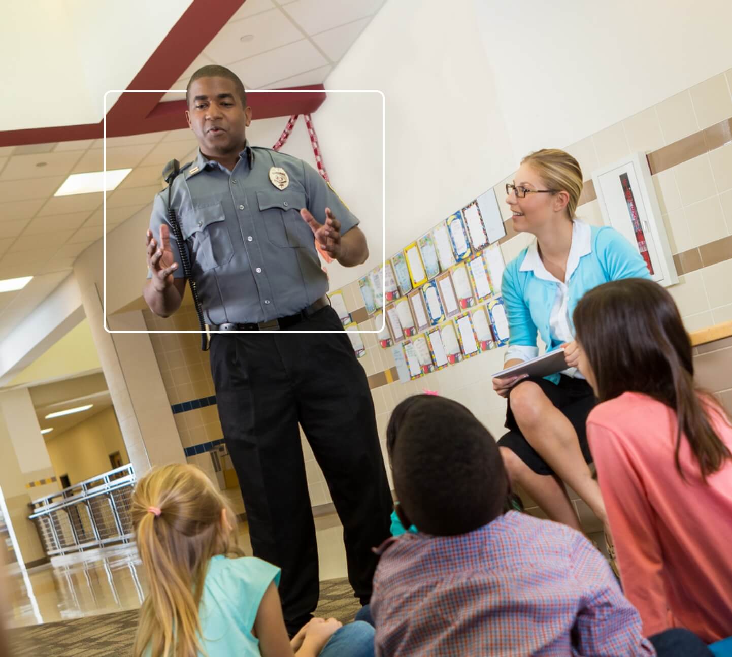 School safety officer speaking to children in school library about safety