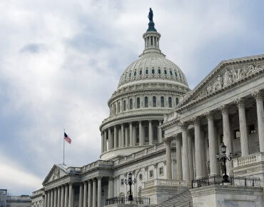 Close-up of the United States Capitol building in Washington, D.C., with the American flag flying nearby