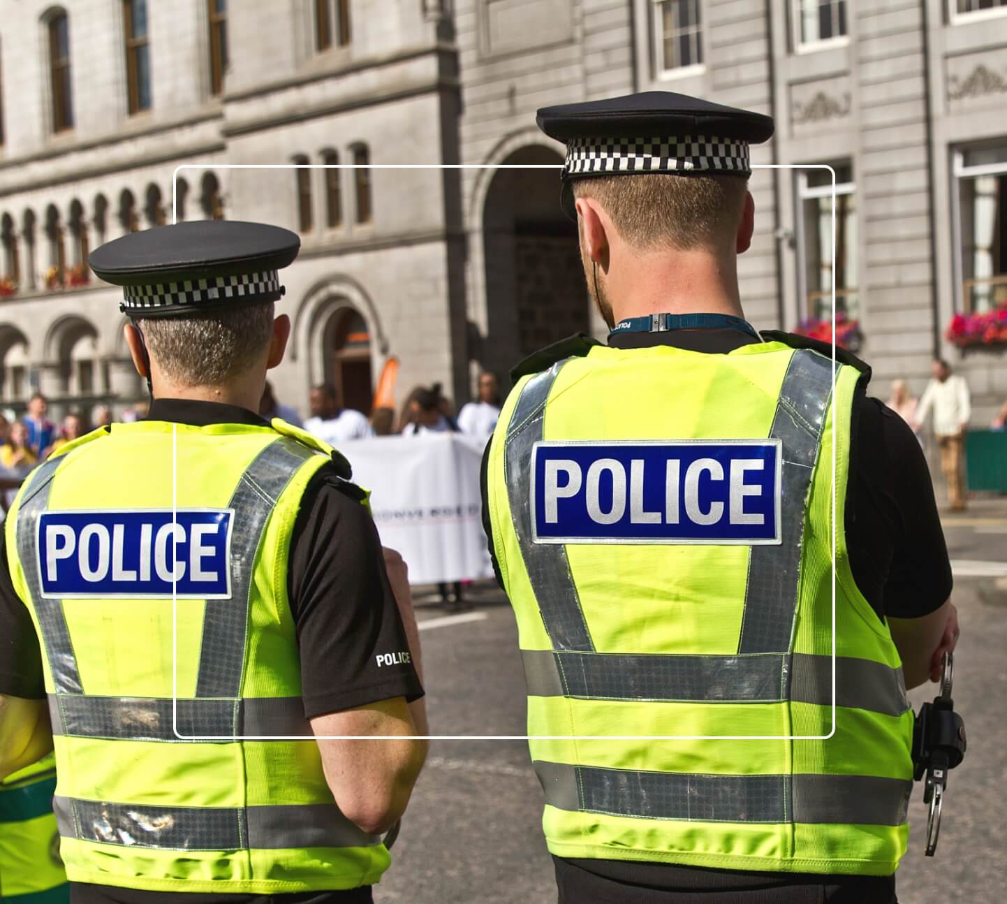 Two UK police officers standing watch over public demonstration