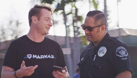 Mark43 team member showing a police officer the platform on his mobile device