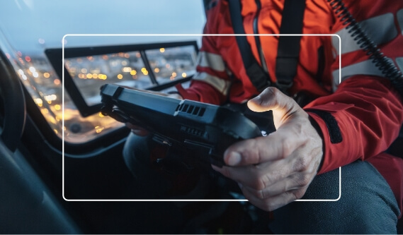 Rescue worker using a handheld device inside a vehicle during an emergency response