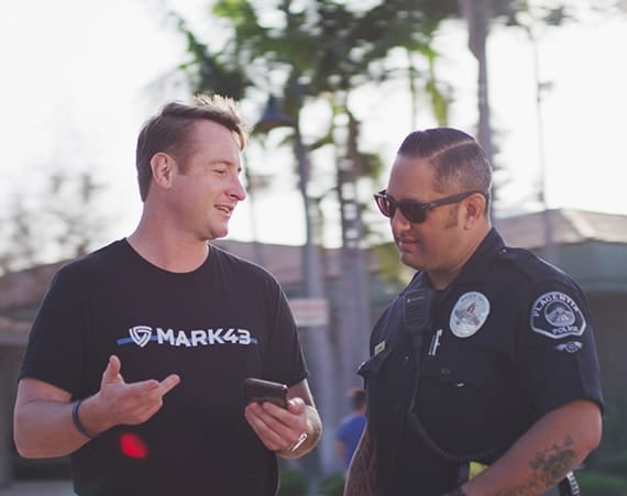 A Mark43 representative conversing with a Placentia Police Department officer outdoors.