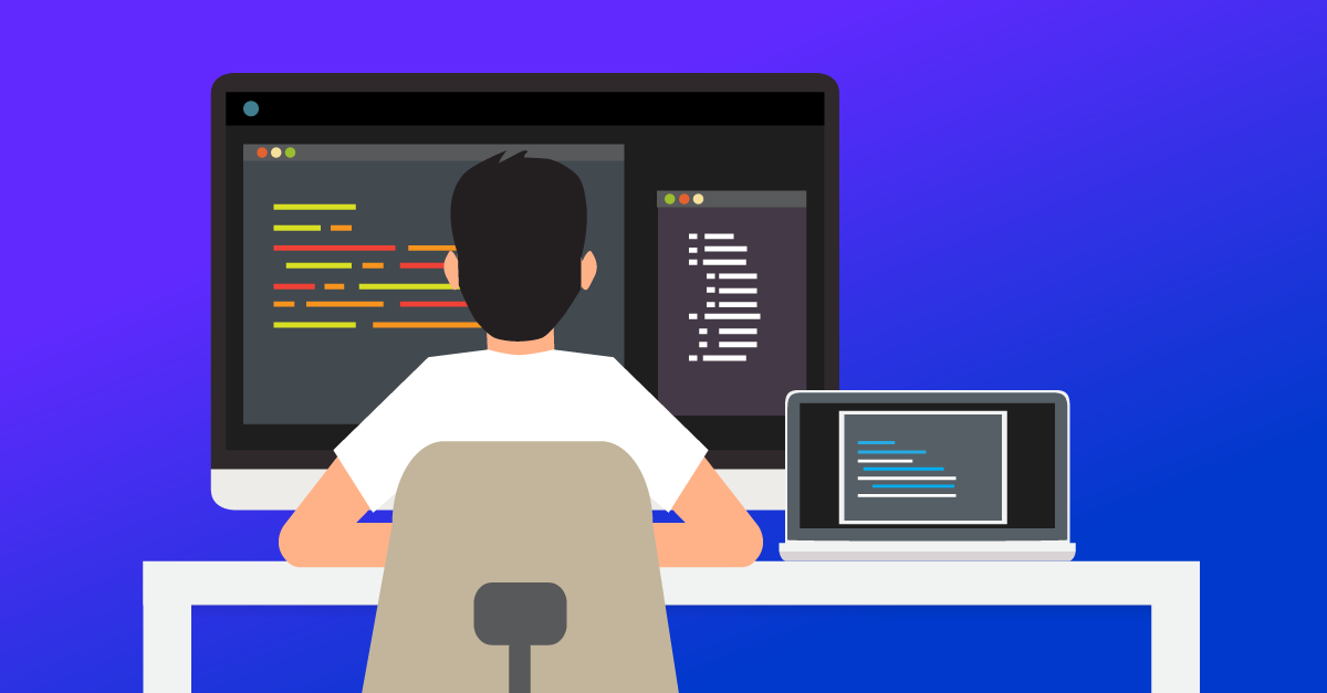 A caucasion individual with black hair sits at a white desk, writing code on a desktop monitor with a laptop sitting on the right of the monitor.